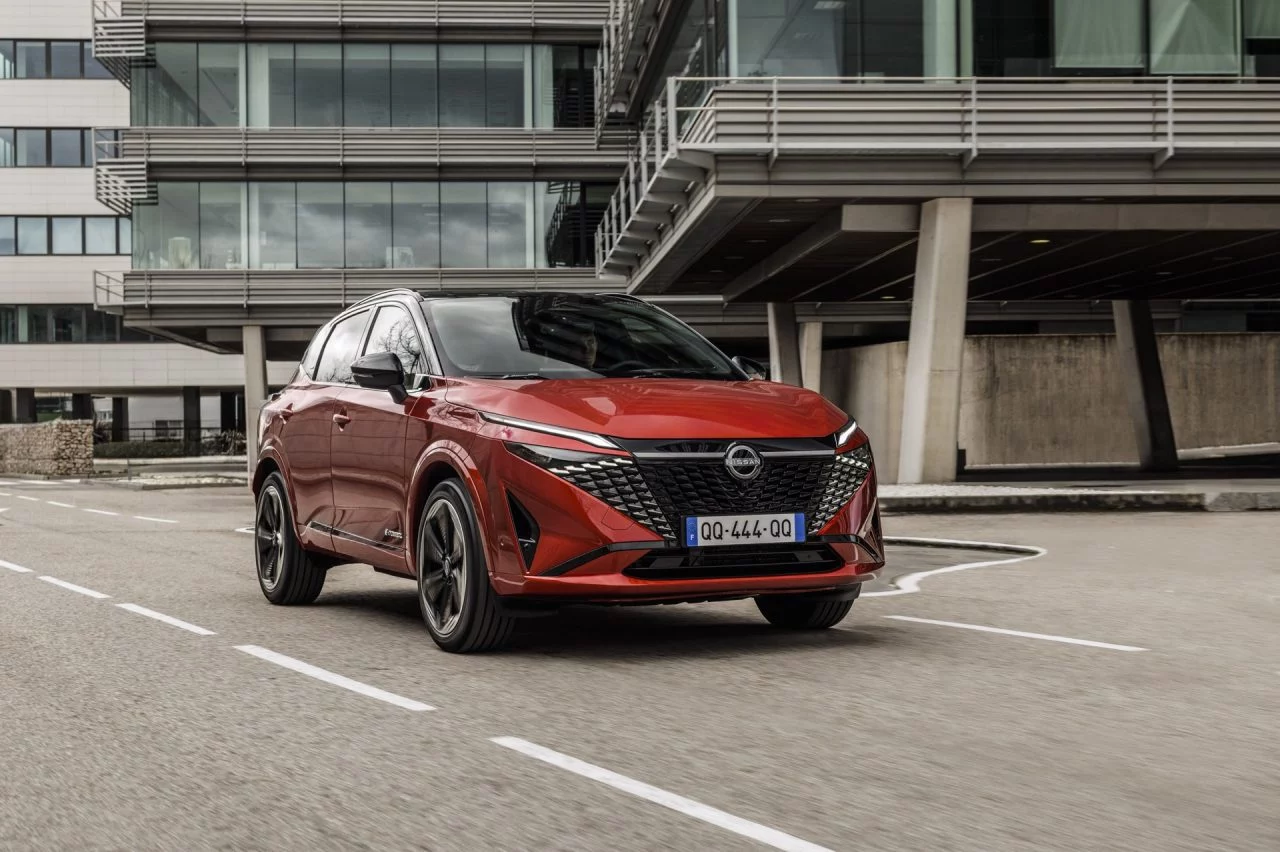 Vista dinámica del Nissan Qashqai 2024 en rojo, destacando su diseño frontal y perfil lateral.