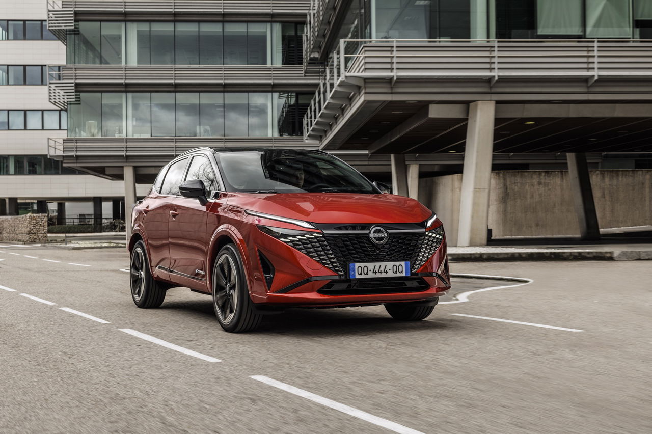 Vista dinámica del Nissan Qashqai 2024 en rojo, destacando su diseño frontal y perfil lateral.