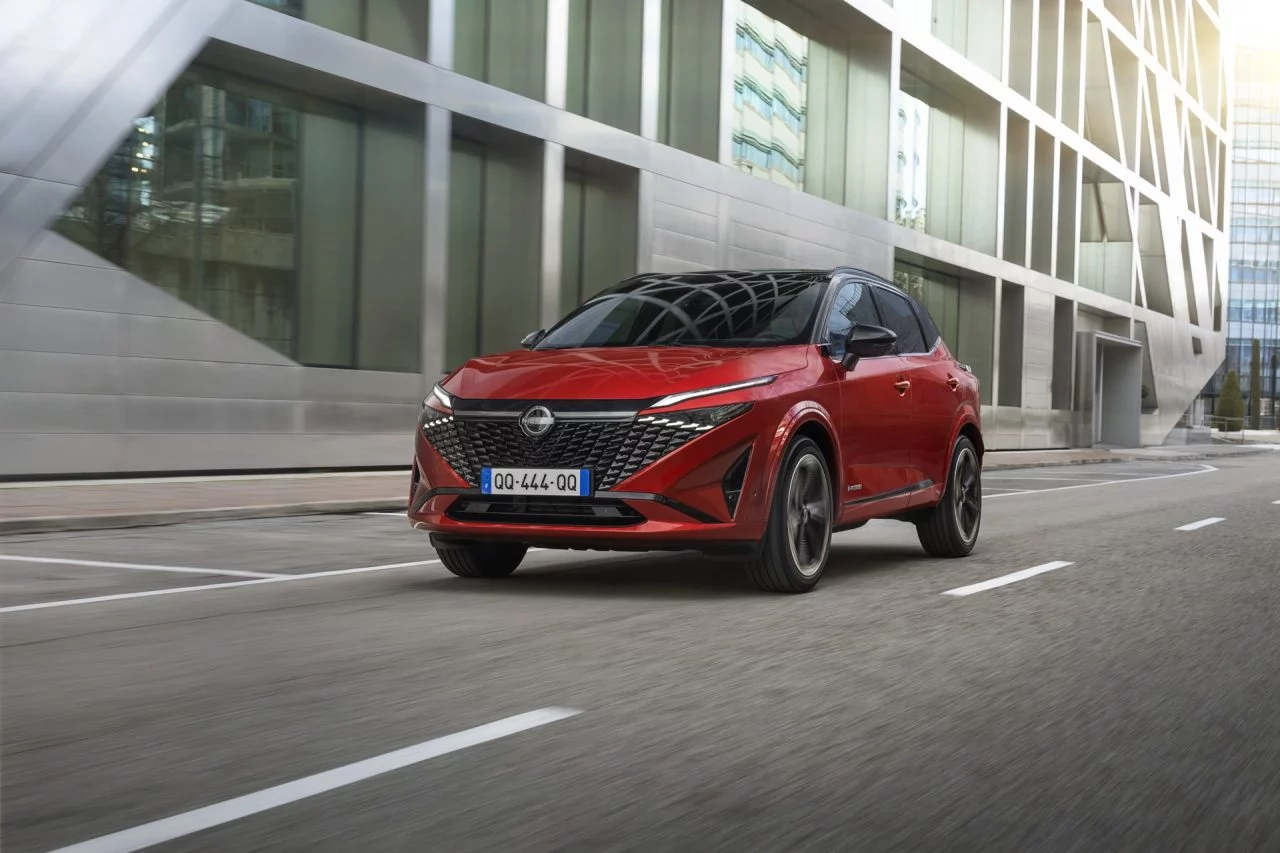 Vista dinámica del Nissan Qashqai 2024 en movimiento, color rojo, destacando su diseño lateral.