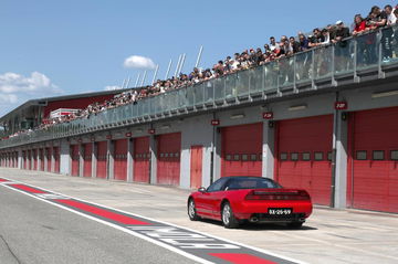 Homenaje a Senna con un deportivo clásico en el pitlane. Colores y diseño icónicos.