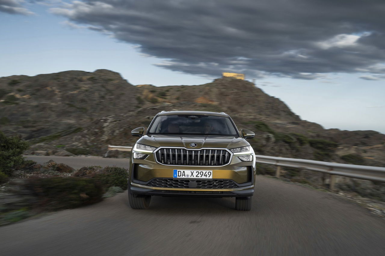 Vista frontal del Škoda Kodiaq 2024 en carretera de montaña, resaltando su robusta parrilla y faros LED.