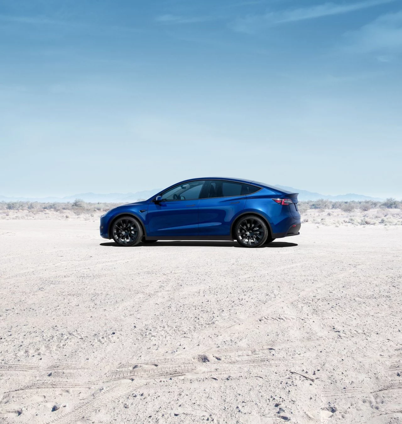 Vista lateral del Tesla Model Y 2024, destacando su diseño aerodinámico y líneas modernas.