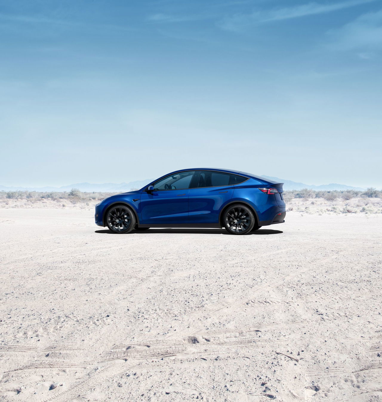 Vista lateral del Tesla Model Y 2024, destacando su diseño aerodinámico y líneas modernas.