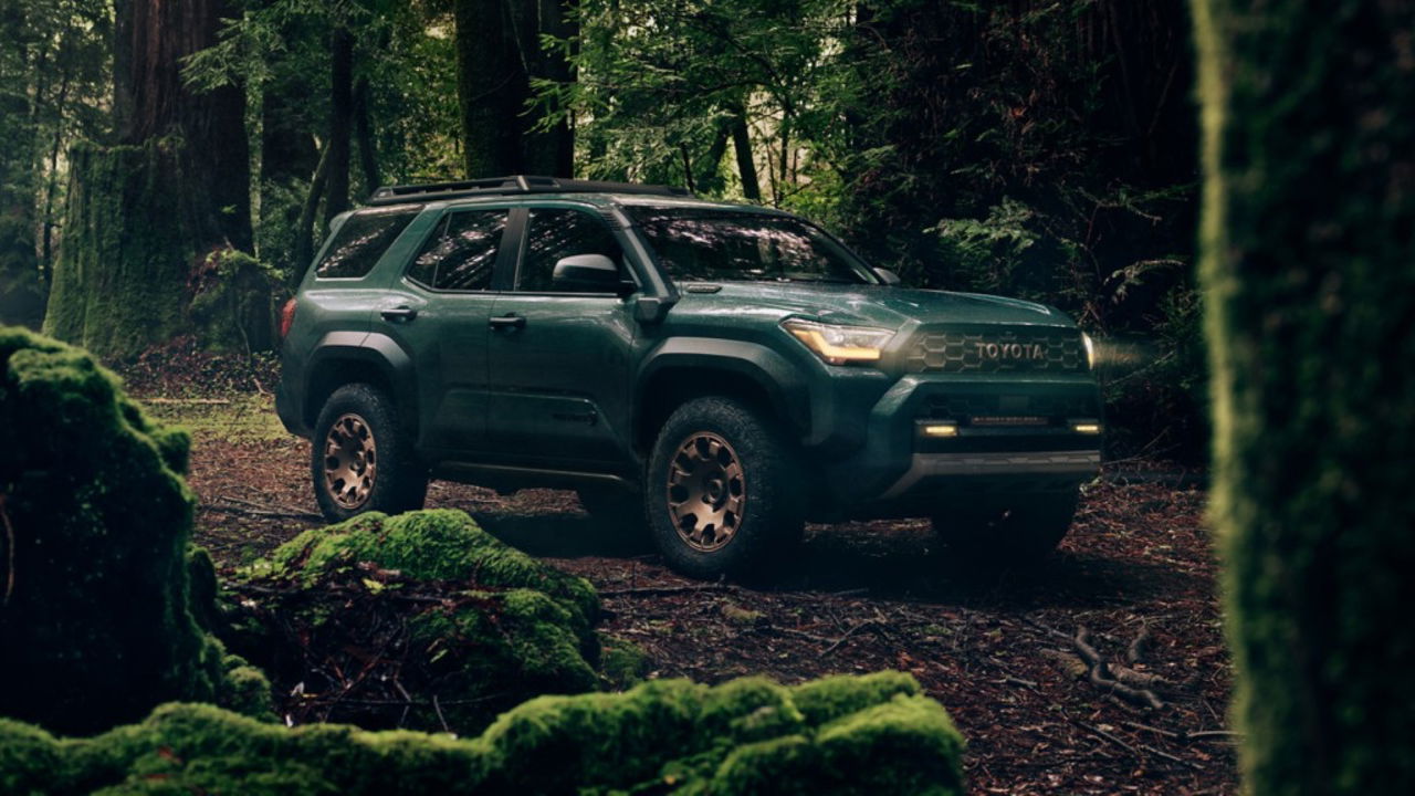 Toyota 4Runner 2024 Trailhunter posando en un bosque húmedo, destacando su perfil robusto.