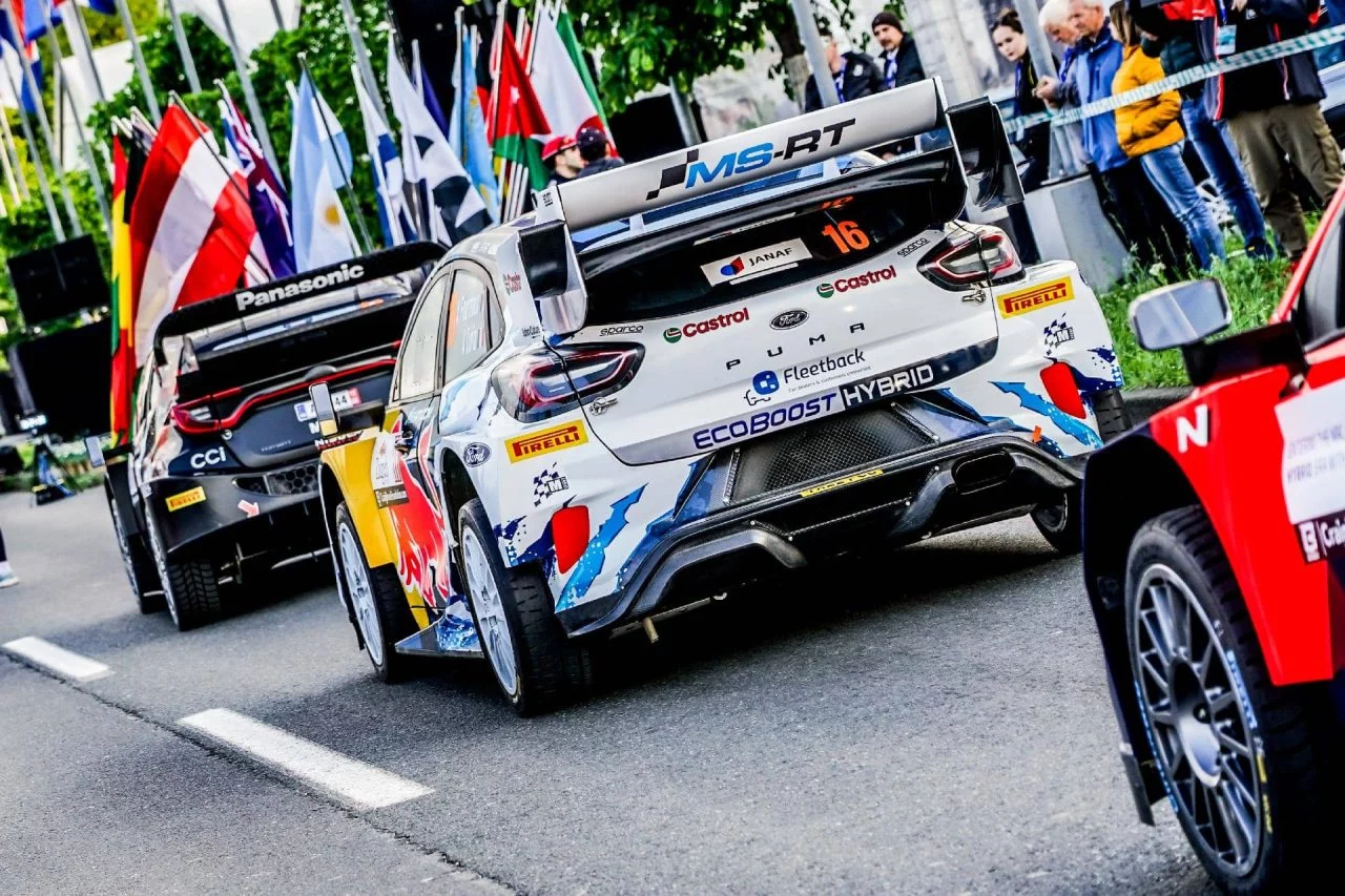 Imagen de un coche de rally WRC desde una perspectiva trasera-lateral enfocando su diseño aerodinámico