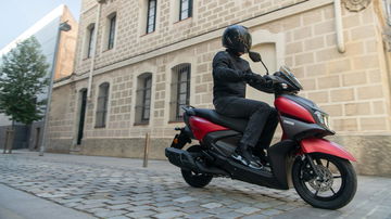 Vista lateral en movimiento de la Yamaha RayZR del 2024 en entorno urbano