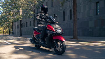 Vista dinámica del Yamaha RayZR en entorno urbano, mostrando su agilidad y diseño deportivo.