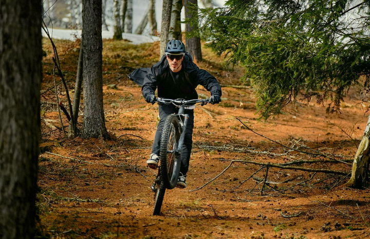 Ciclista maniobrando una ebike a través de terreno forestal