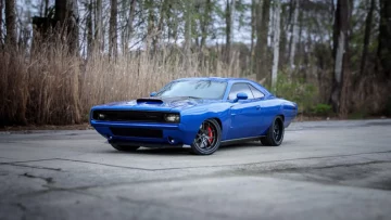 Dodge Challenger clásico en impecable estado, color azul, destacando su lado ícono americano.