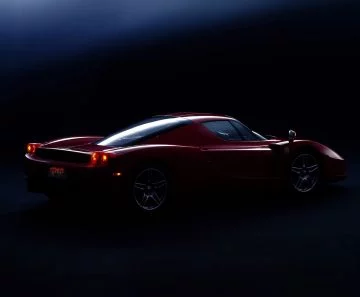 Vista trasera y lateral del icónico Ferrari Enzo, destacando su linea aerodinámica y neumáticos.