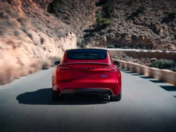 Vista dinámica de la trasera del Tesla Model Y enfatizando sus líneas suaves y modernas luces LED.