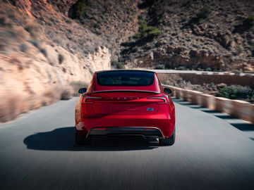 Vista dinámica de la trasera del Tesla Model Y enfatizando sus líneas suaves y modernas luces LED.