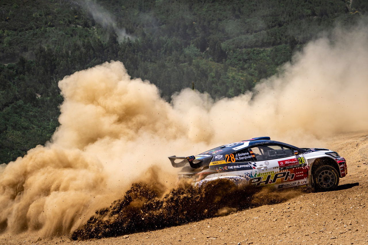 Vehículo de rally derrapando en superficie de tierra con habilidad y precisión.