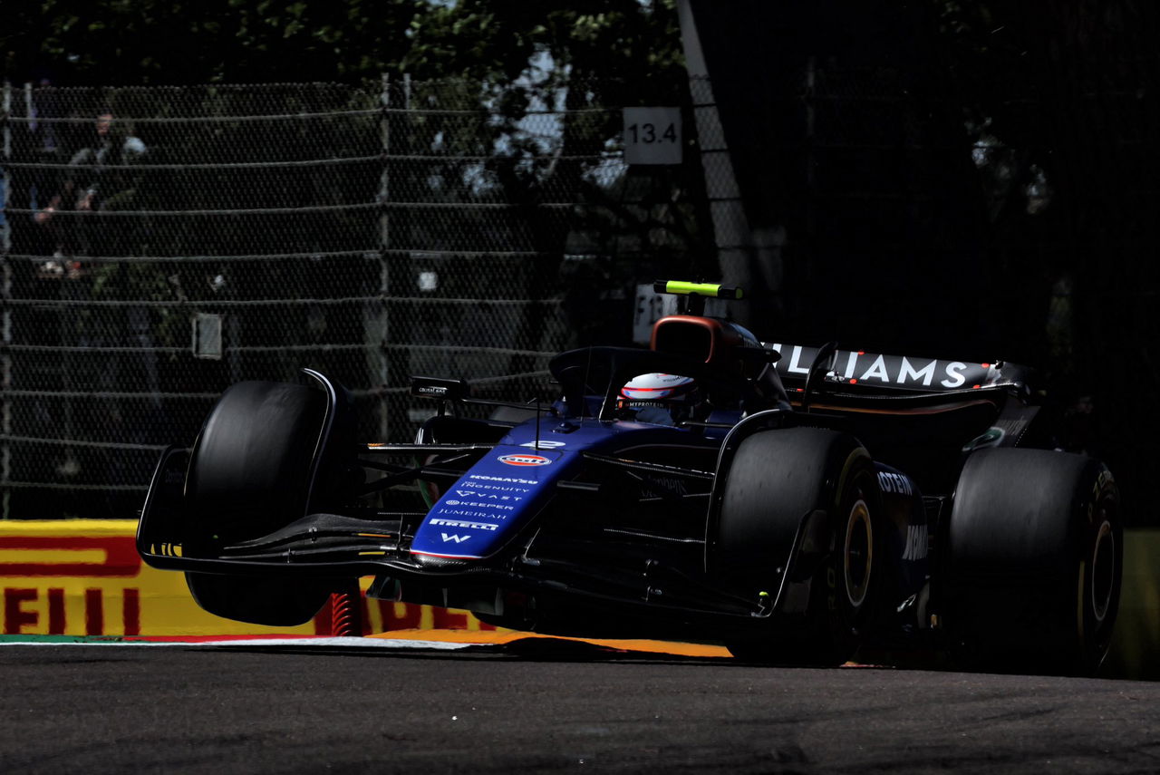 Monoplaza en acción en el GP de Imola, destacando la aerodinámica lateral.