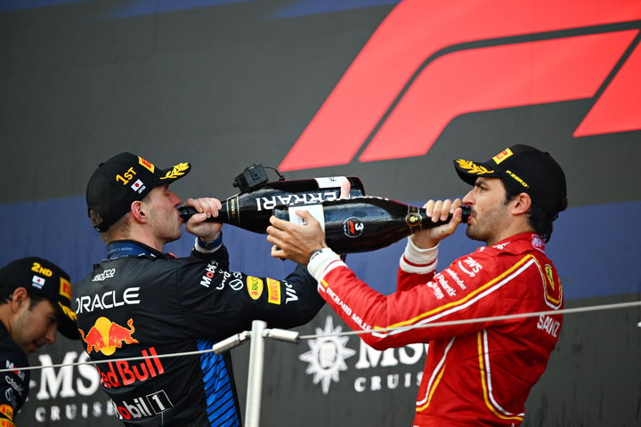 Dos pilotos de F1 celebrando en el podio, botella de champán en mano