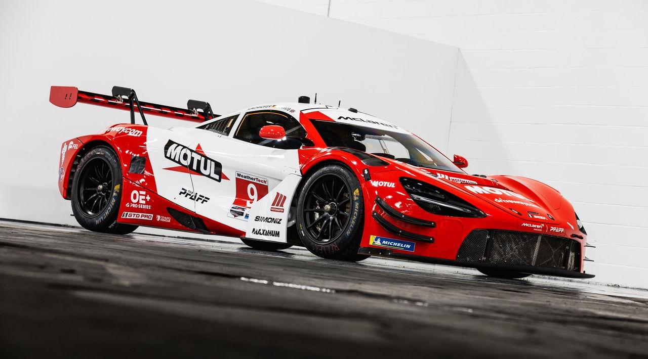 McLaren enmarcado en rojo y blanco en Laguna Seca, preparado para competir.