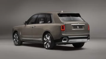 Elegante visión trasera y lateral del Rolls-Royce Cullinan, mostrando su imponente estampa.