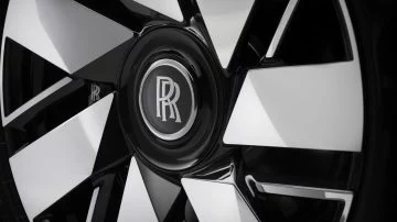 Primer plano de la lujosa rueda del Rolls-Royce Cullinan con su emblemático emblema.