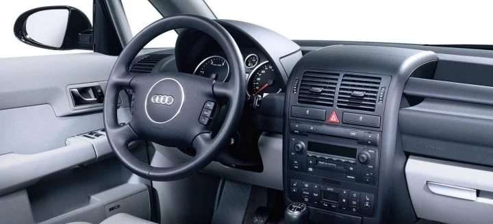 Vista lateral del interior del Audi A2, destacando su ergonomía y calidad de acabados.