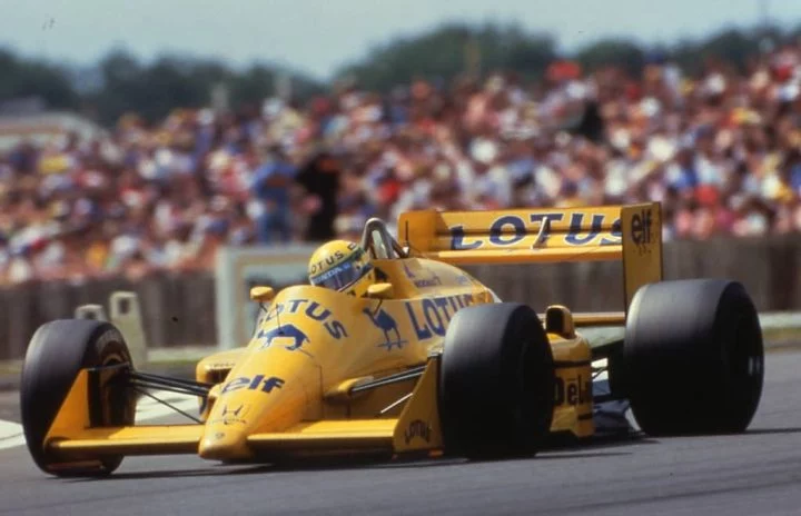 Lotus de F1 en acción, colores icónicos del casco de Ayrton Senna visibles