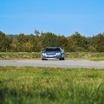 Vista frontal y lateral de un Bentley Continental GT en carretera rural.