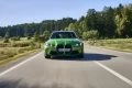 BMW sedán verde en movimiento, muestra elegancia y potencia.