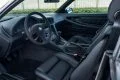 Vista lateral del impecable interior de un BMW Serie 8, asientos de cuero y acabados premium.