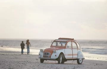 Citroën 2CV en una edición limitada mostrando su perfil clásico en la playa.
