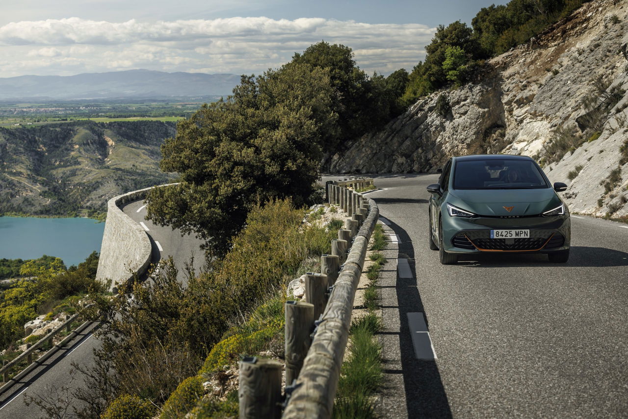 Vista impresionante del Cupra Born avanzando por una carretera serpenteante.