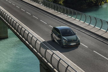 Vista lateral del Cupra Born VZ en movimiento sobre un puente