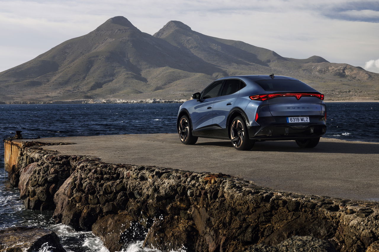 Vista lateral CUPRA Tavascan VZ eléctrico con montañas al fondo