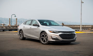 Vista angular frontal del Chevrolet Malibu en su hábitat urbano, enfoque claro en diseño y estética