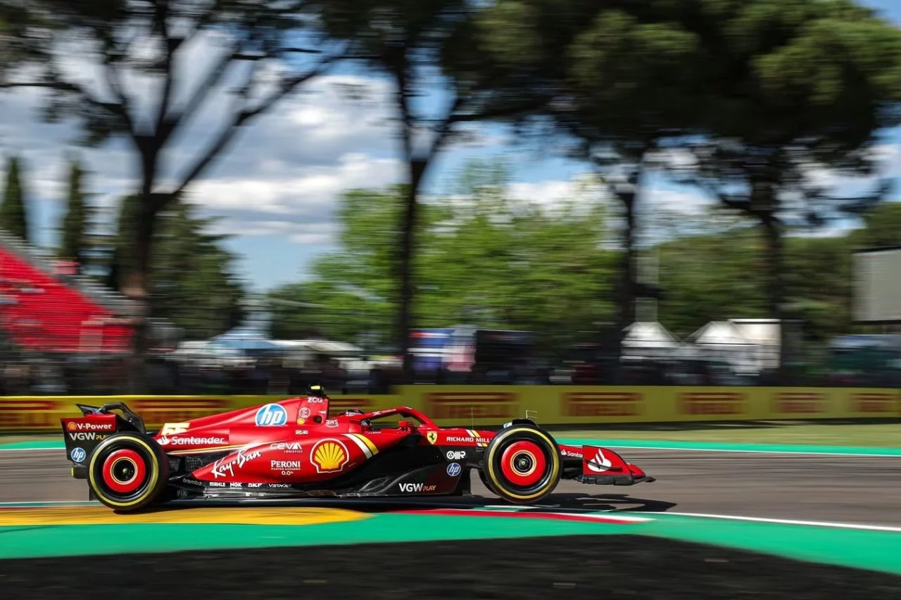 Carlos Sainz al volante del Ferrari, tomando la curva con maestría, rumbo a la parrilla de salida.