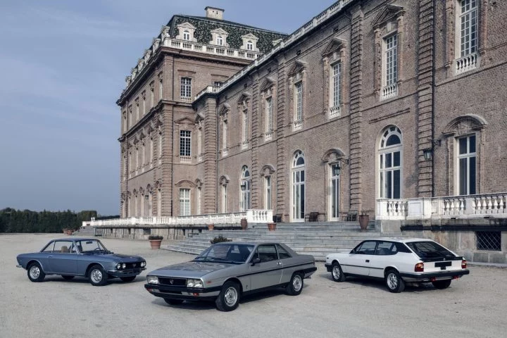 Tres joyas de Lancia: Fulvia, Gamma Coupé y Beta HPE frente a palacio.