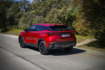 Vista dinámica de un SUV compacto en color rojo, destacando su diseño moderno y líneas aerodinámicas.