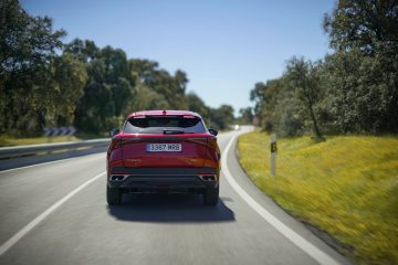 Vista trasera del SUV en carretera, diseño moderno y robusto.