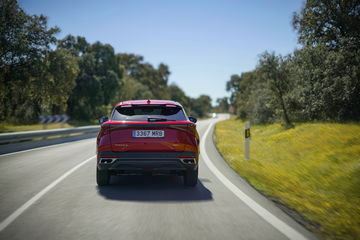 Vista trasera del SUV en carretera, diseño moderno y robusto.