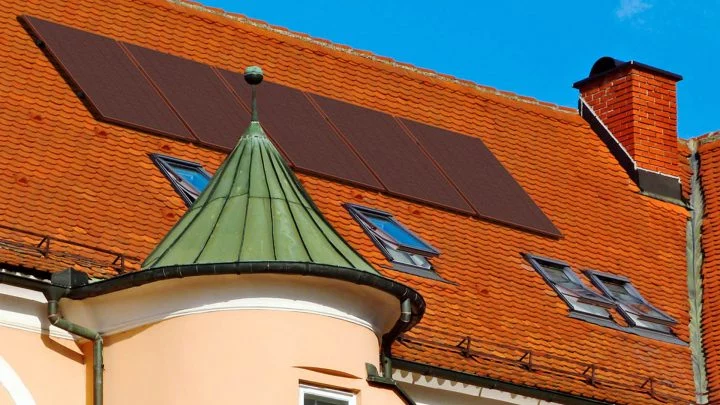 Paneles solares en tono terracota integrados en tejado, estética revolucionaria.