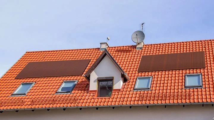 Paneles solares en tonalidad terracota integrados armoniosamente en tejado residencial
