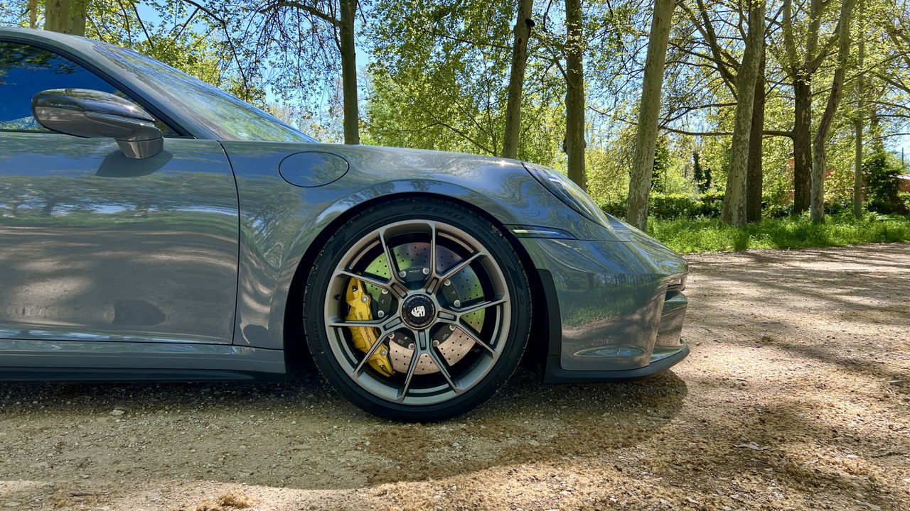 Vista lateral del Porsche 911 GT3 Touring que destaca sus llantas y frenos deportivos.