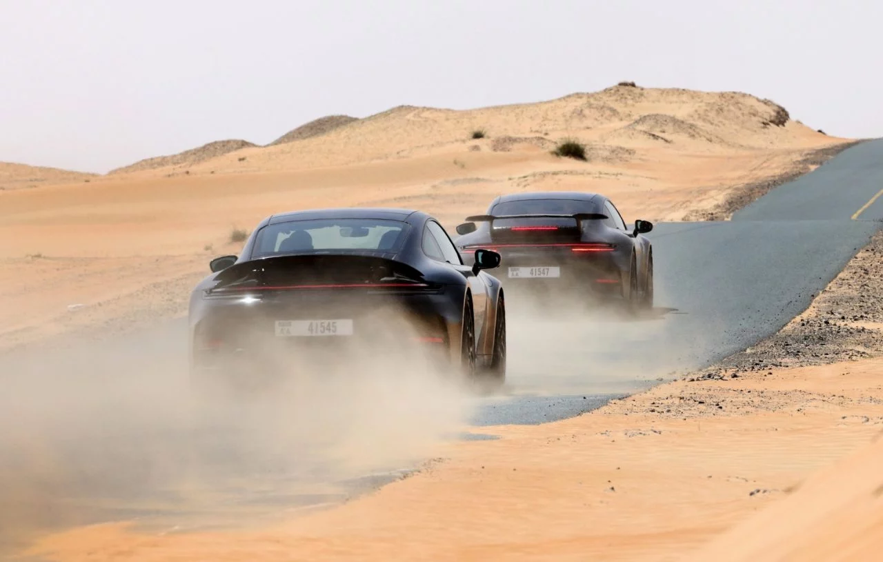 Vista dinámica del Porsche 911 híbrido mostrando su silueta y desempeño en ambiente desértico