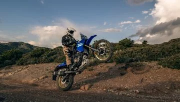 Motorista elevando rueda delantera Yamaha Ténéré 700 en terreno off-road