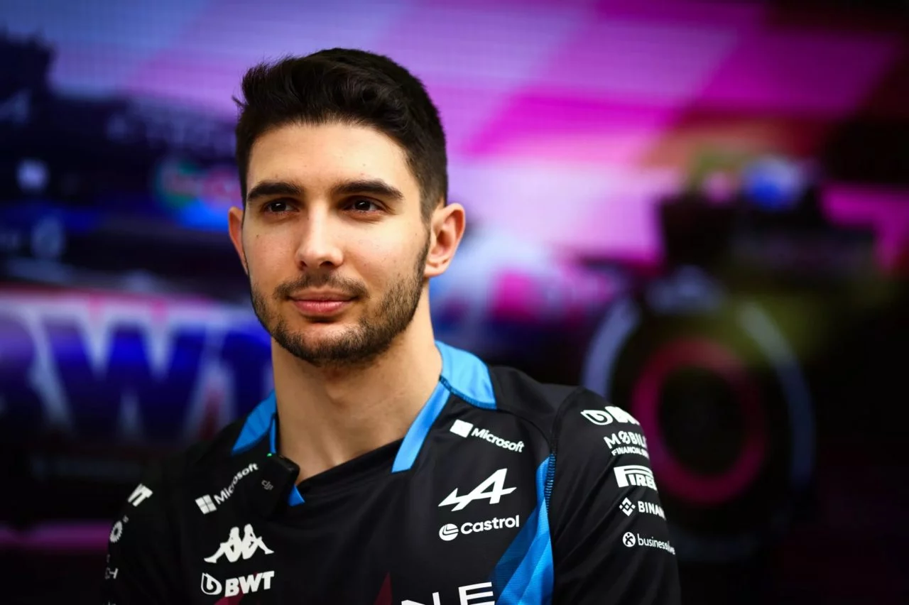 Retrato de Esteban Ocon con colores del equipo Alpine en el fondo.