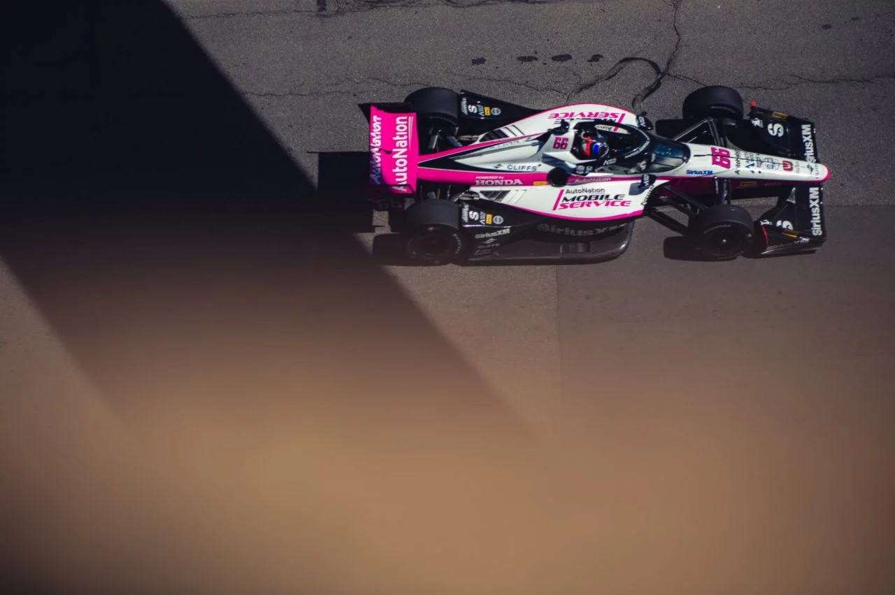 Monoplaza de IndyCar en acción, enfocado en la sección media-lateral.