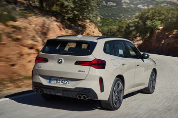 Vista dinámica del BMW X3 M50i XDrive, mostrando su potente zaga y líneas agresivas.