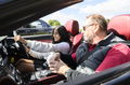 Instructor y alumno en clase de conducción en un lujoso Mercedes convertible.