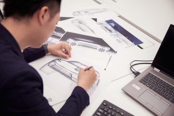 Diseñador perfilando líneas del futuro Volvo EX90 Excellence sobre papel.