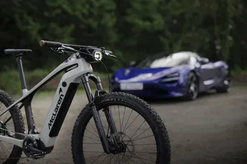 La eBike de McLaren 4x4 destaca con su potente motor frente al vehículo.