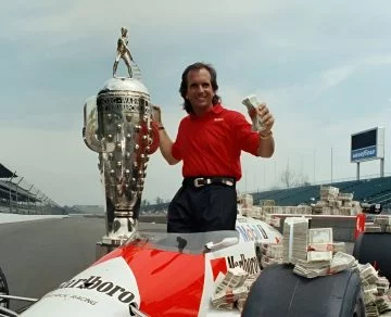 Emerson Fittipaldi celebra victoria Indy 500 con trofeo y premio.
