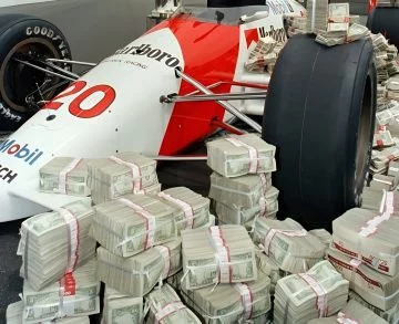 Emerson Fittipaldi junto a premio Indy 500, un hito en automovilismo.